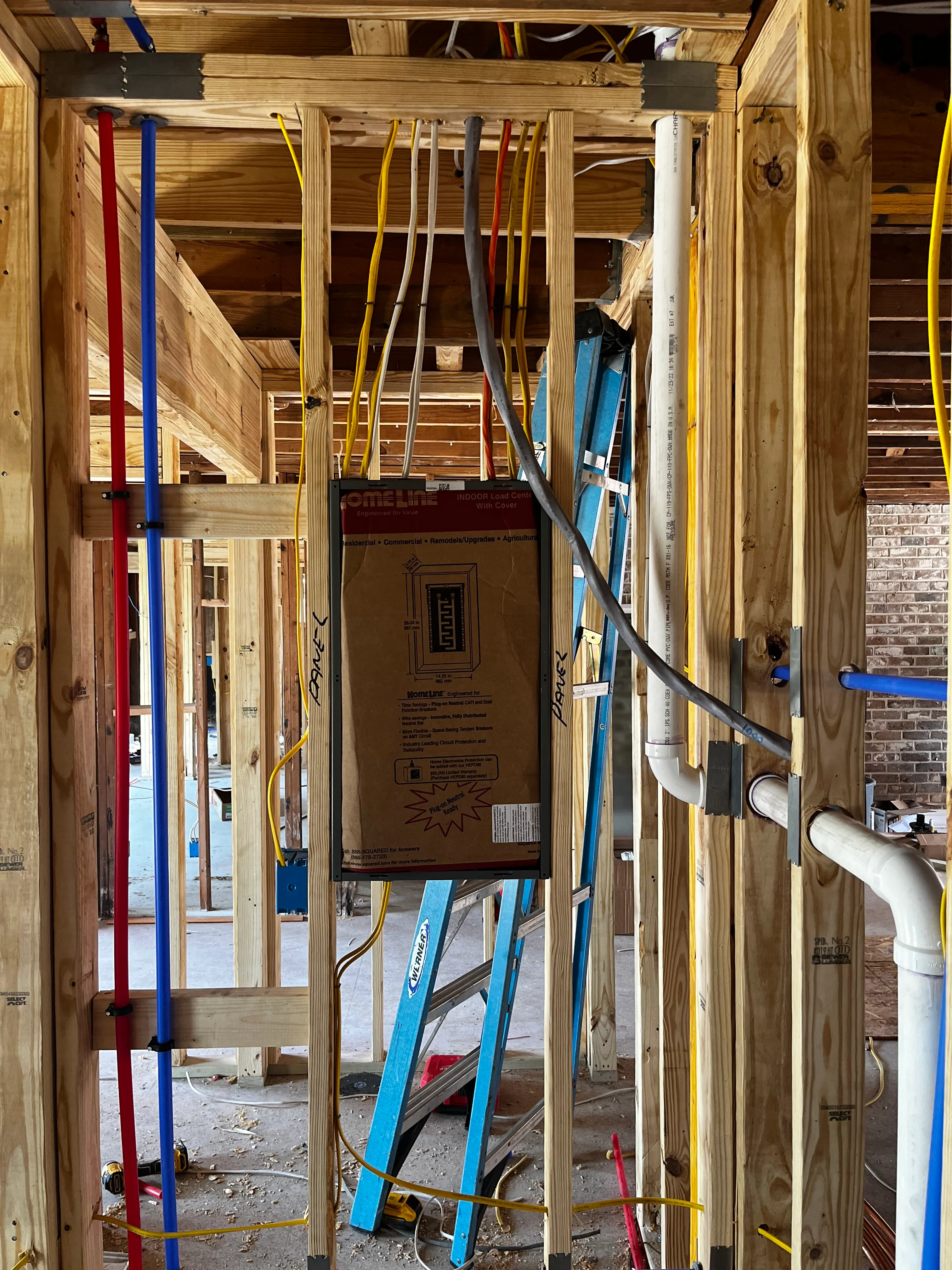 Interior framing with electrical conduit, plumbing, and HVAC rough-in during construction