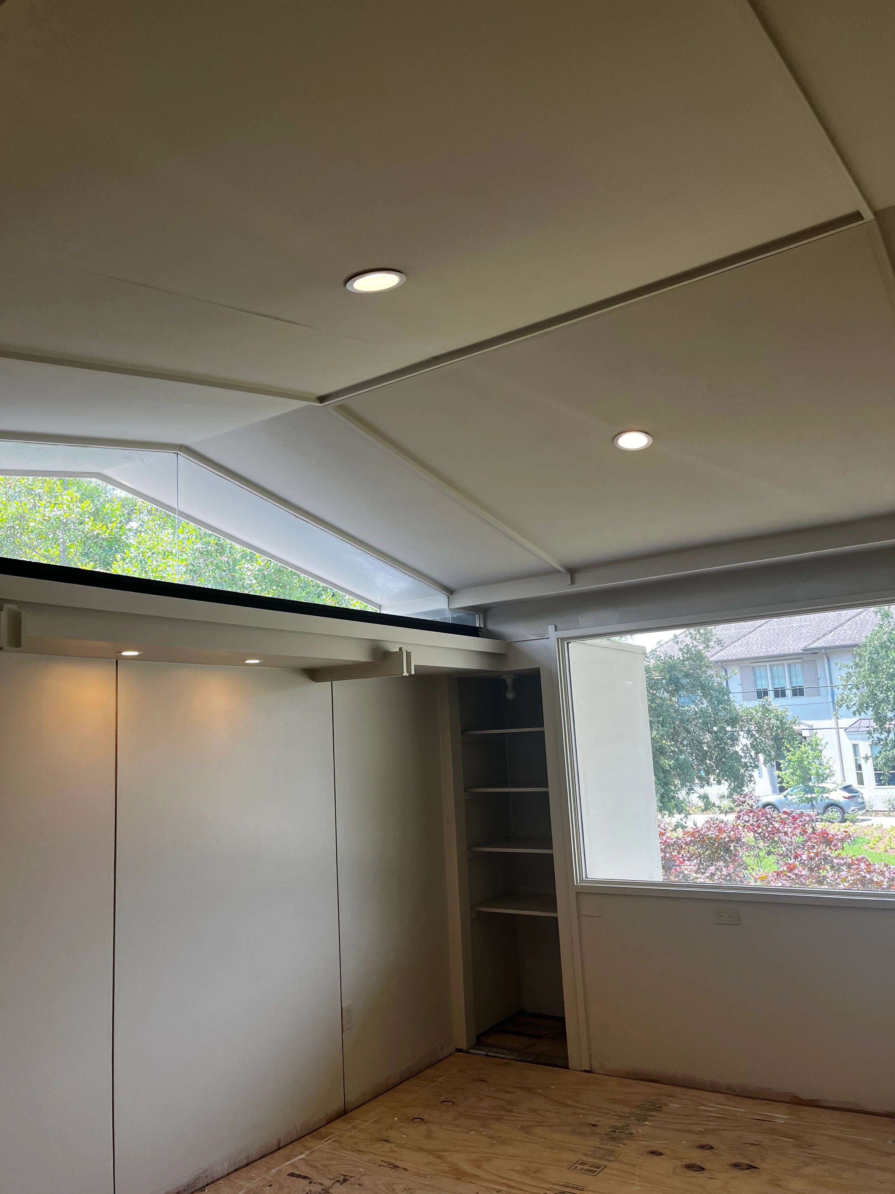 Finished basement interior with recessed lighting, white drywall, and large window