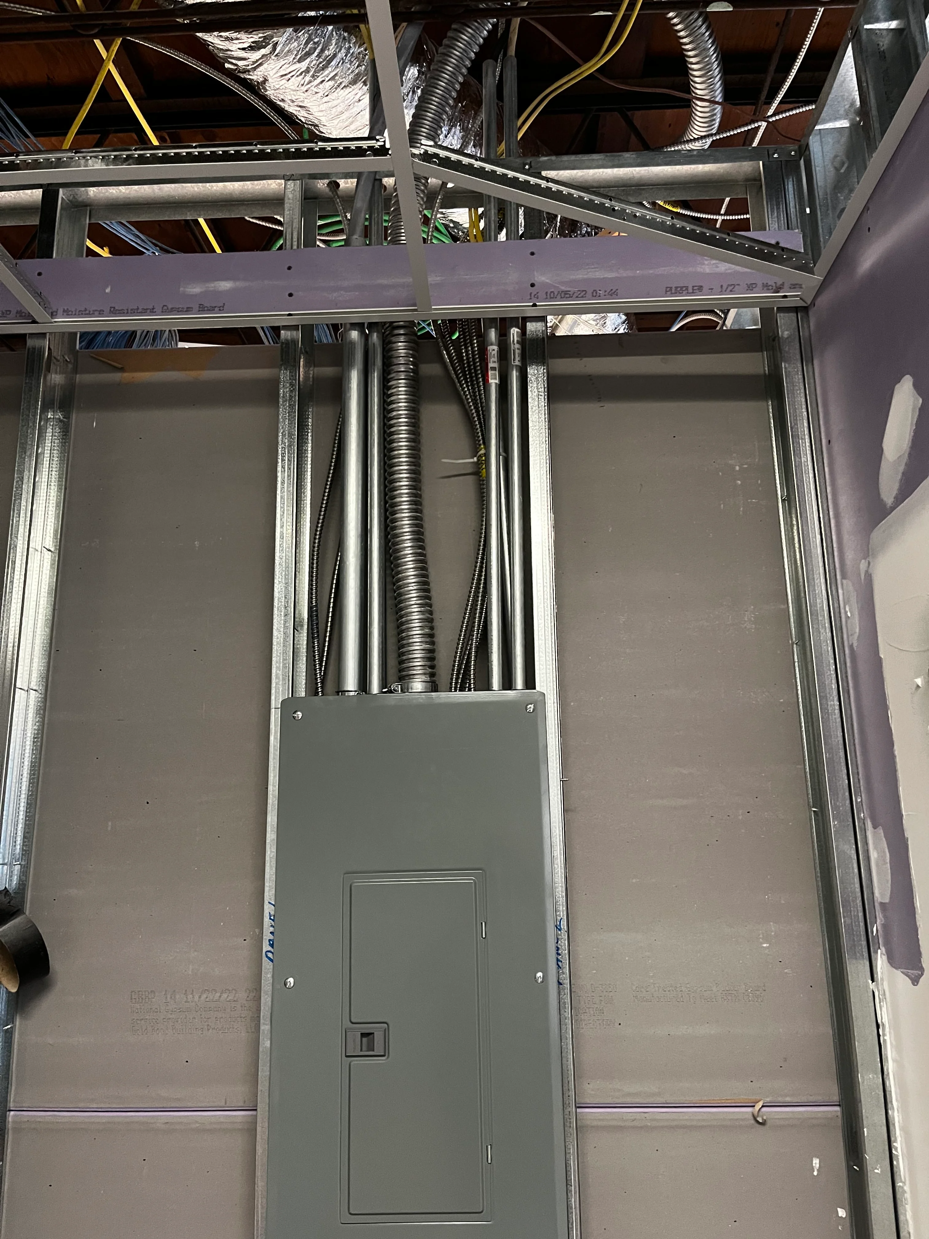 Commercial electrical panel with organized conduit routing and metal framing infrastructure