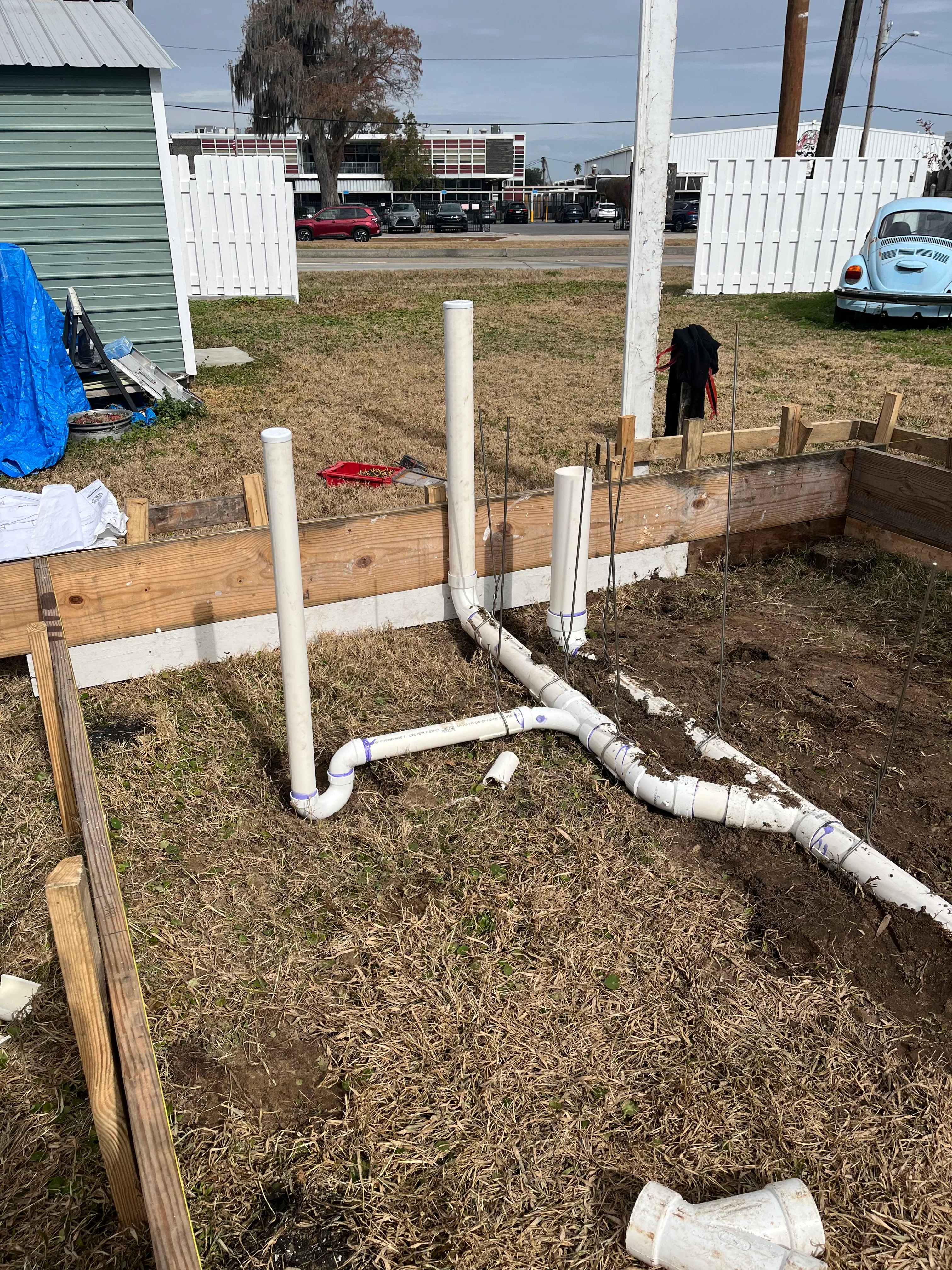 PVC plumbing system installed in raised wooden garden bed with vertical and horizontal pipes