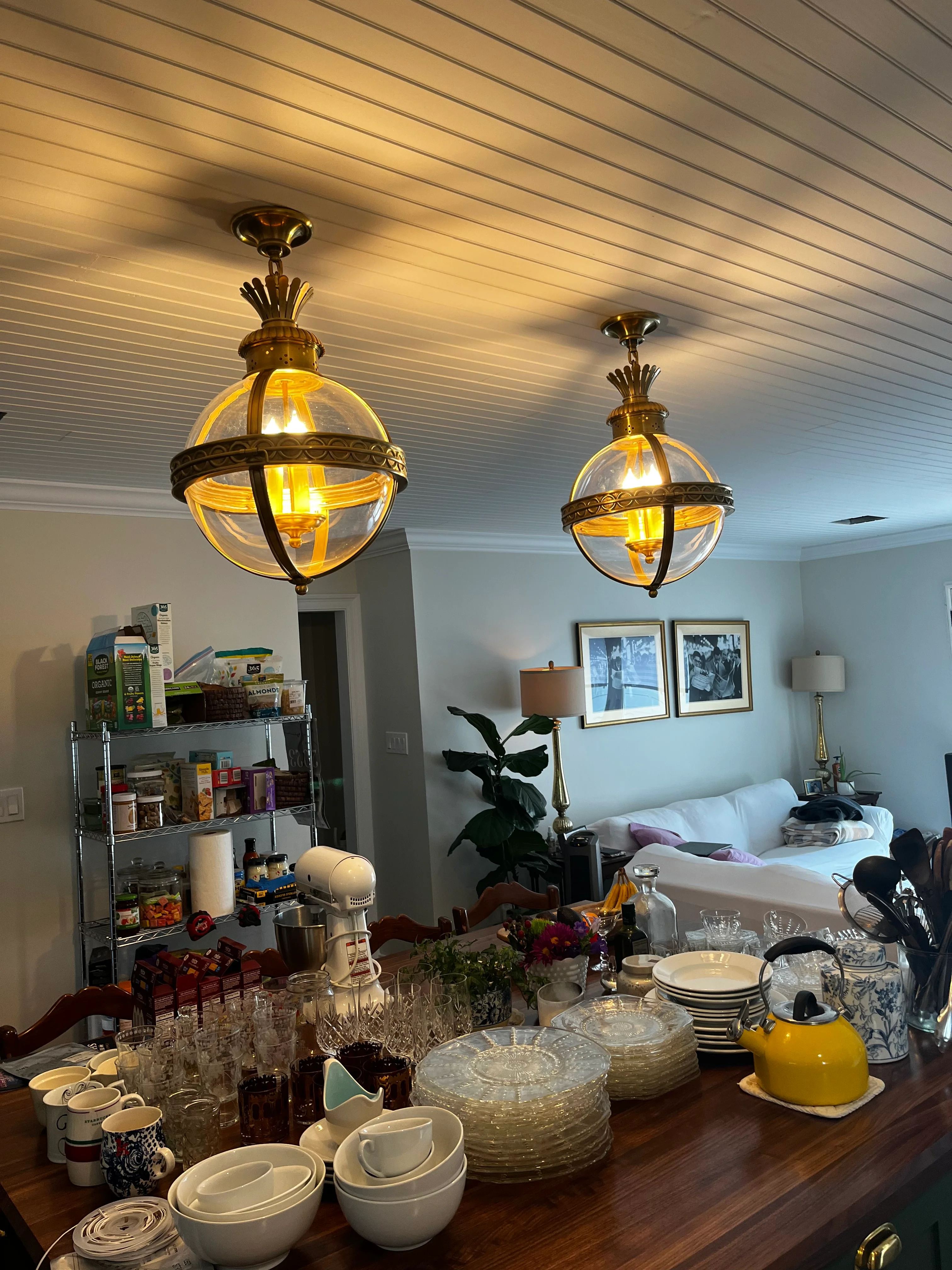 Kitchen with linear shiplap ceiling, two brass globe pendant lights, and updated cabinetry