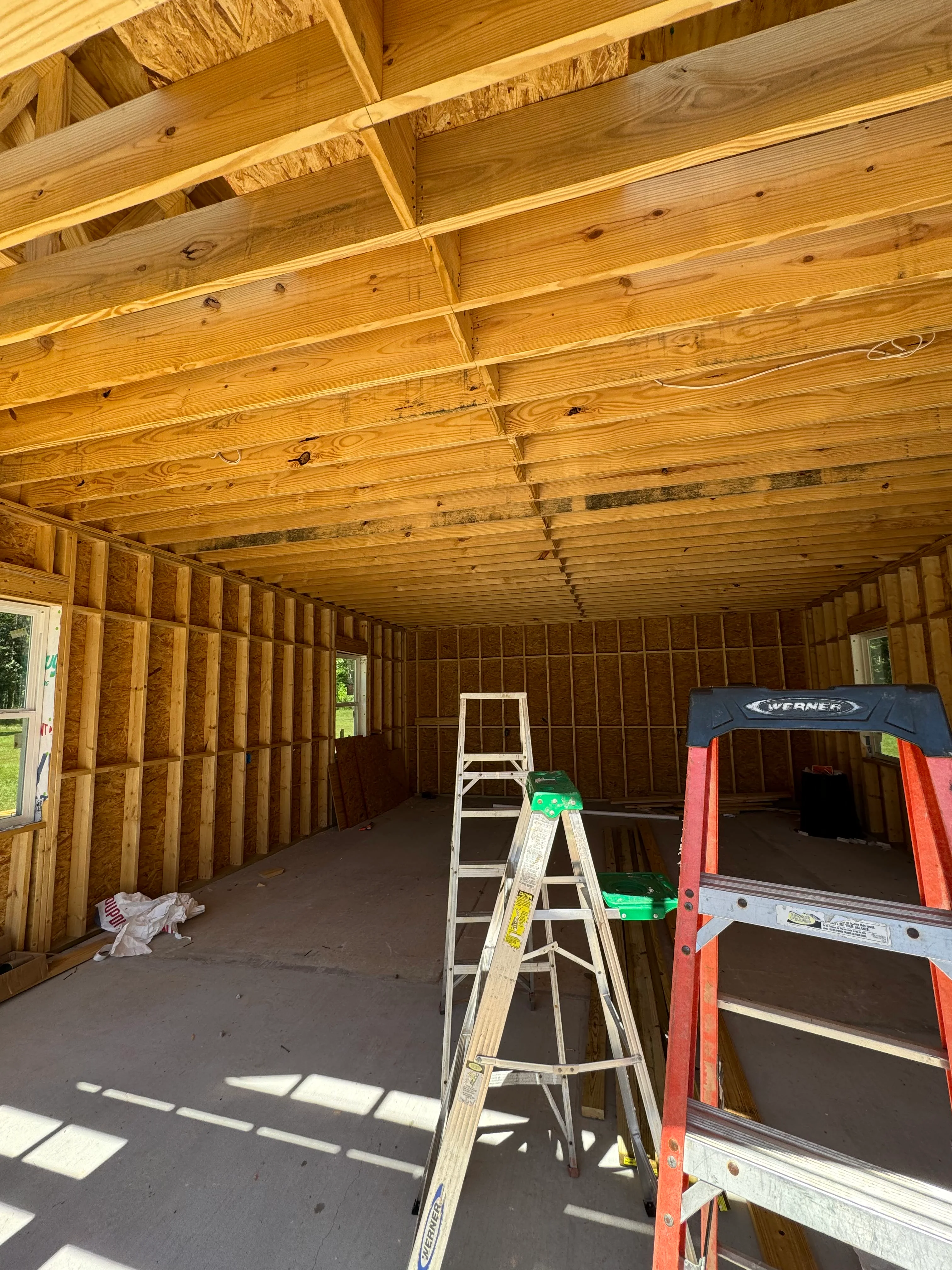 Interior framing with wooden beams, studs, and OSB sheathing during construction phase