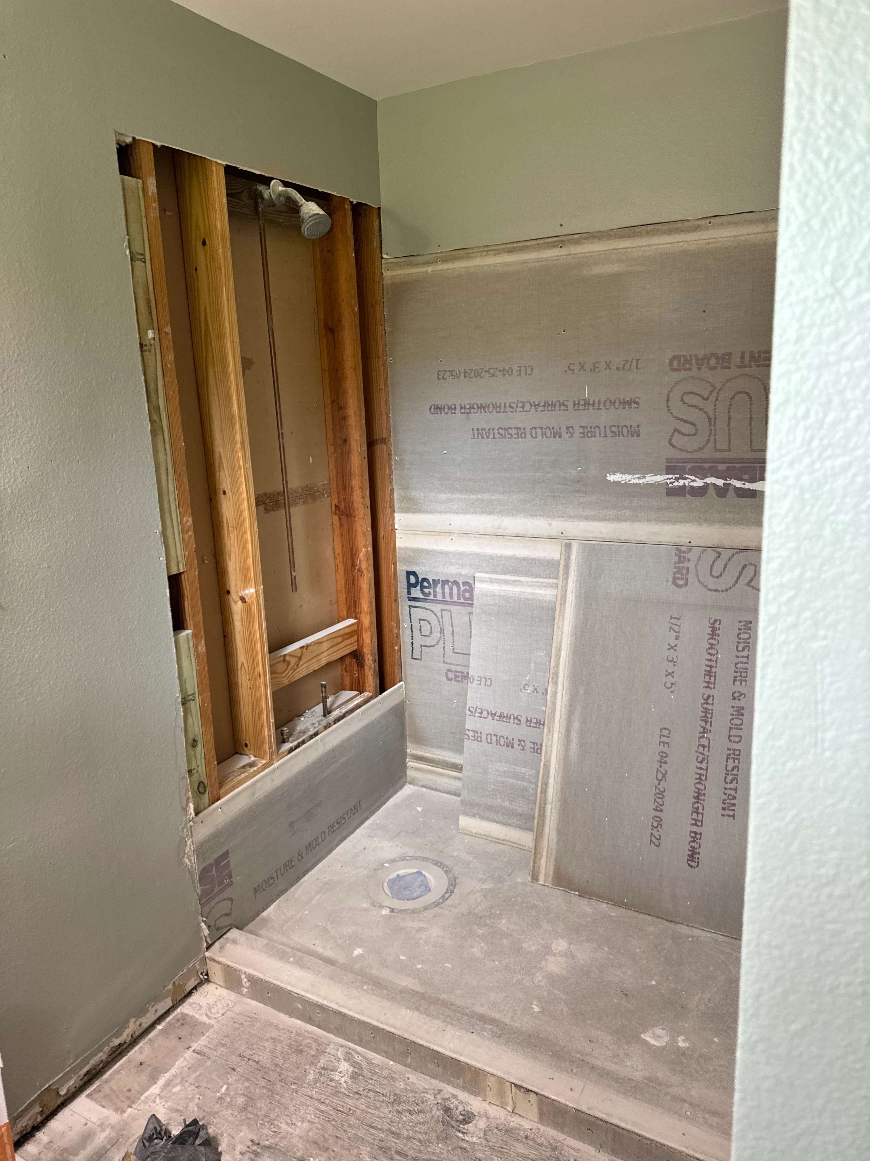 Bathroom shower enclosure under construction with wooden frame and concrete base pan