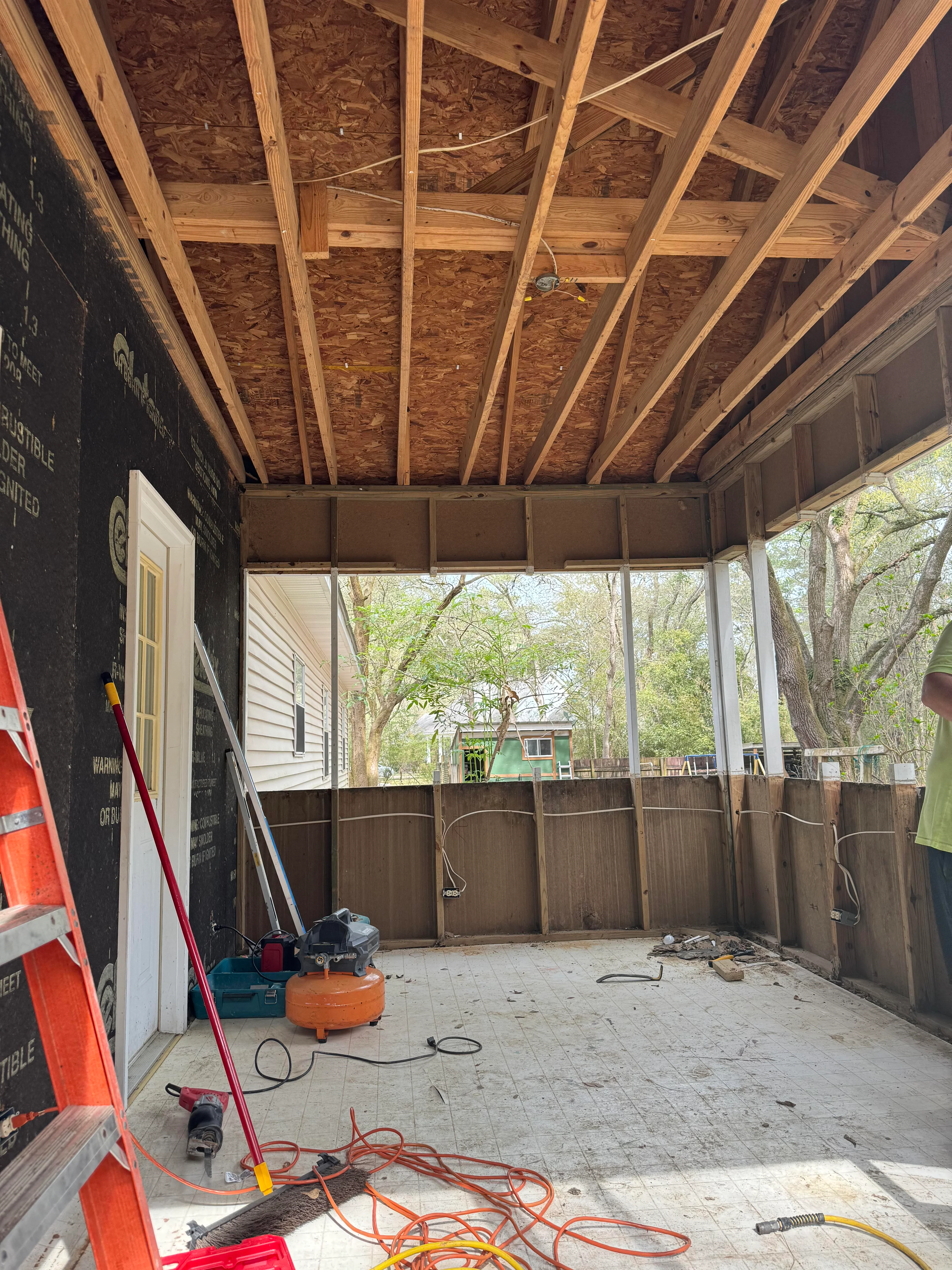 Wooden patio framing with joists and OSB sheathing during construction phase