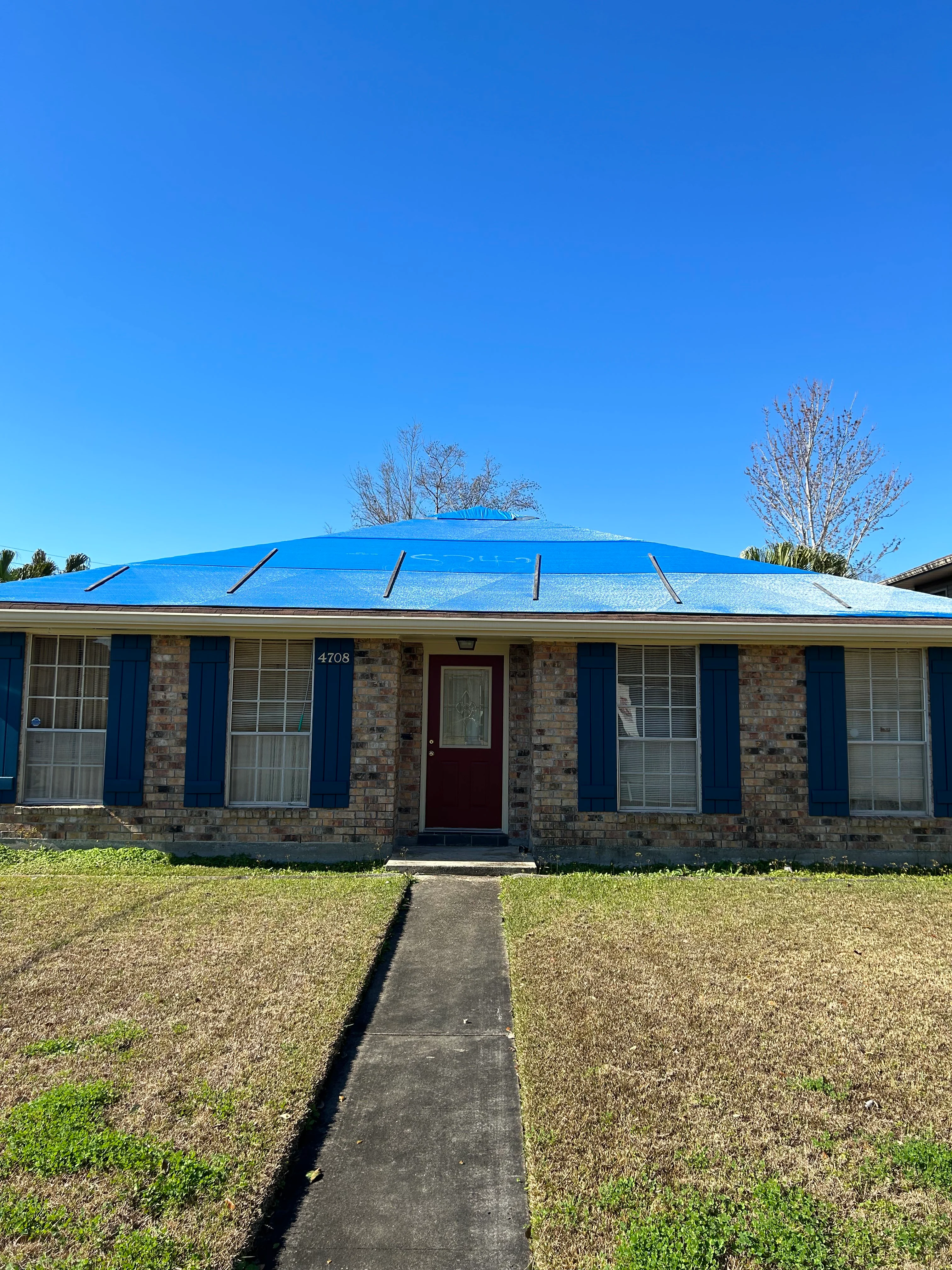 Blue metal roof on brick home with standing seams and roof jacks installed