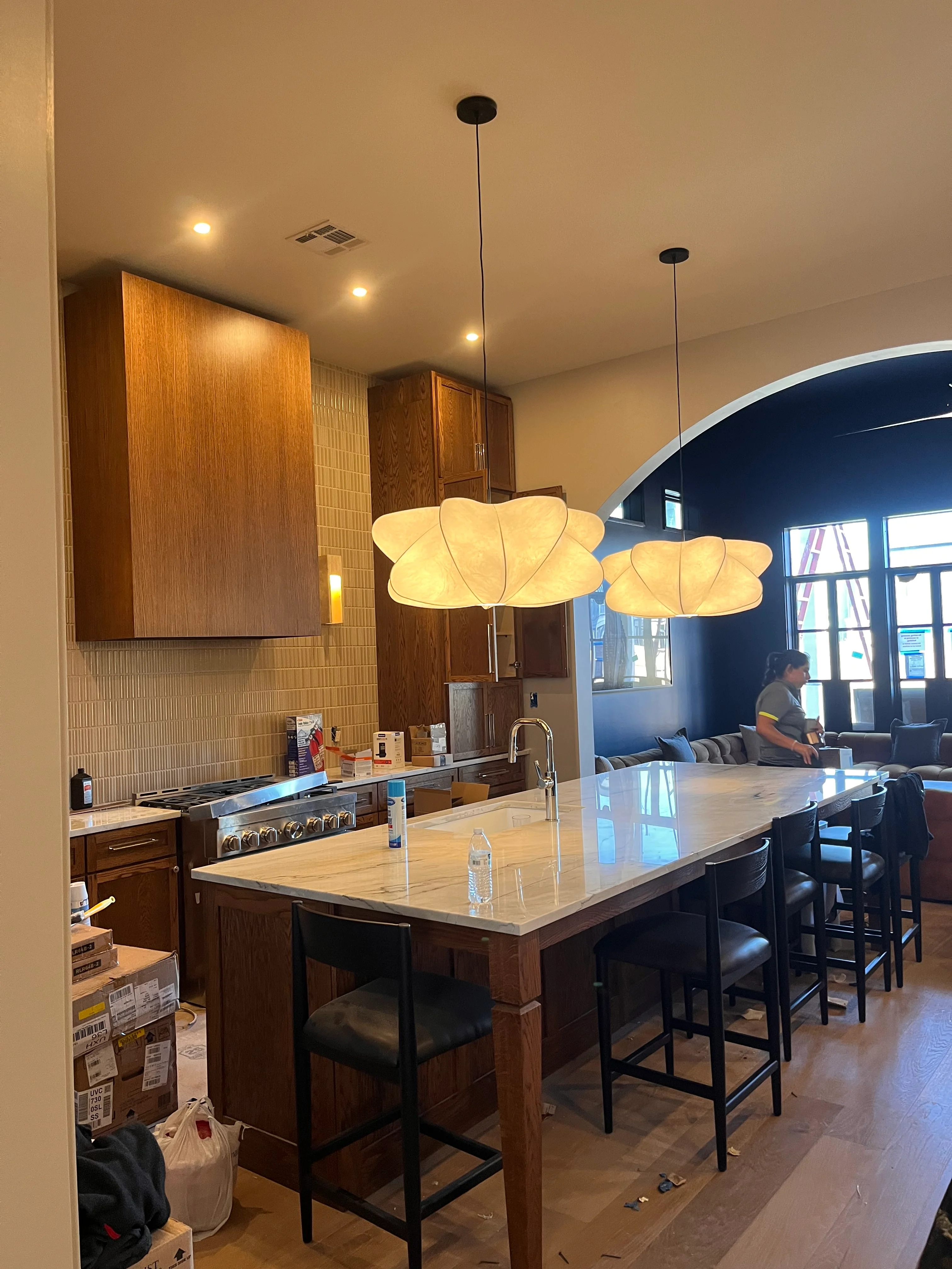 Modern kitchen with dark wood cabinets, marble island, and pendant lighting