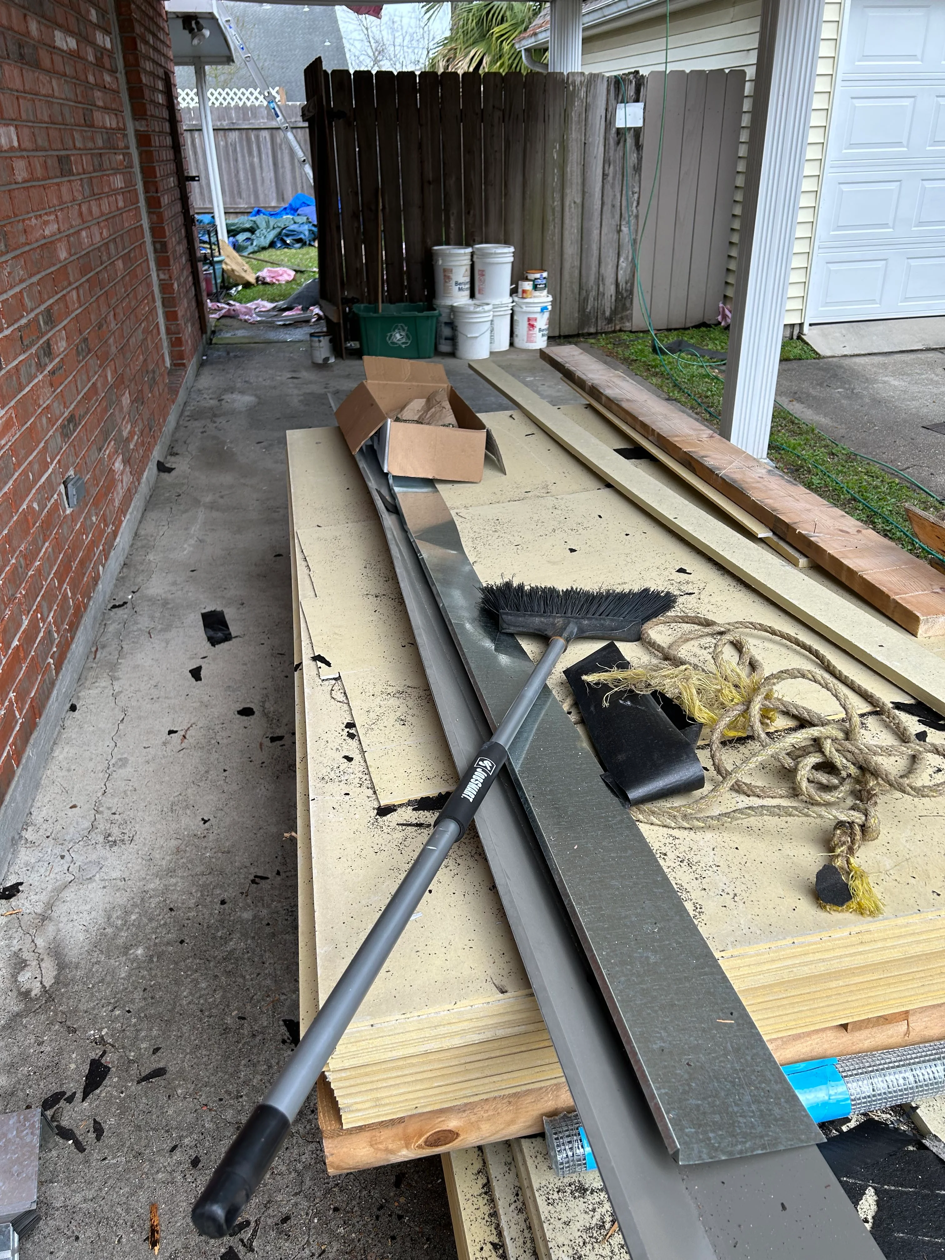 Metal gutter sections and downspout materials staged for residential installation