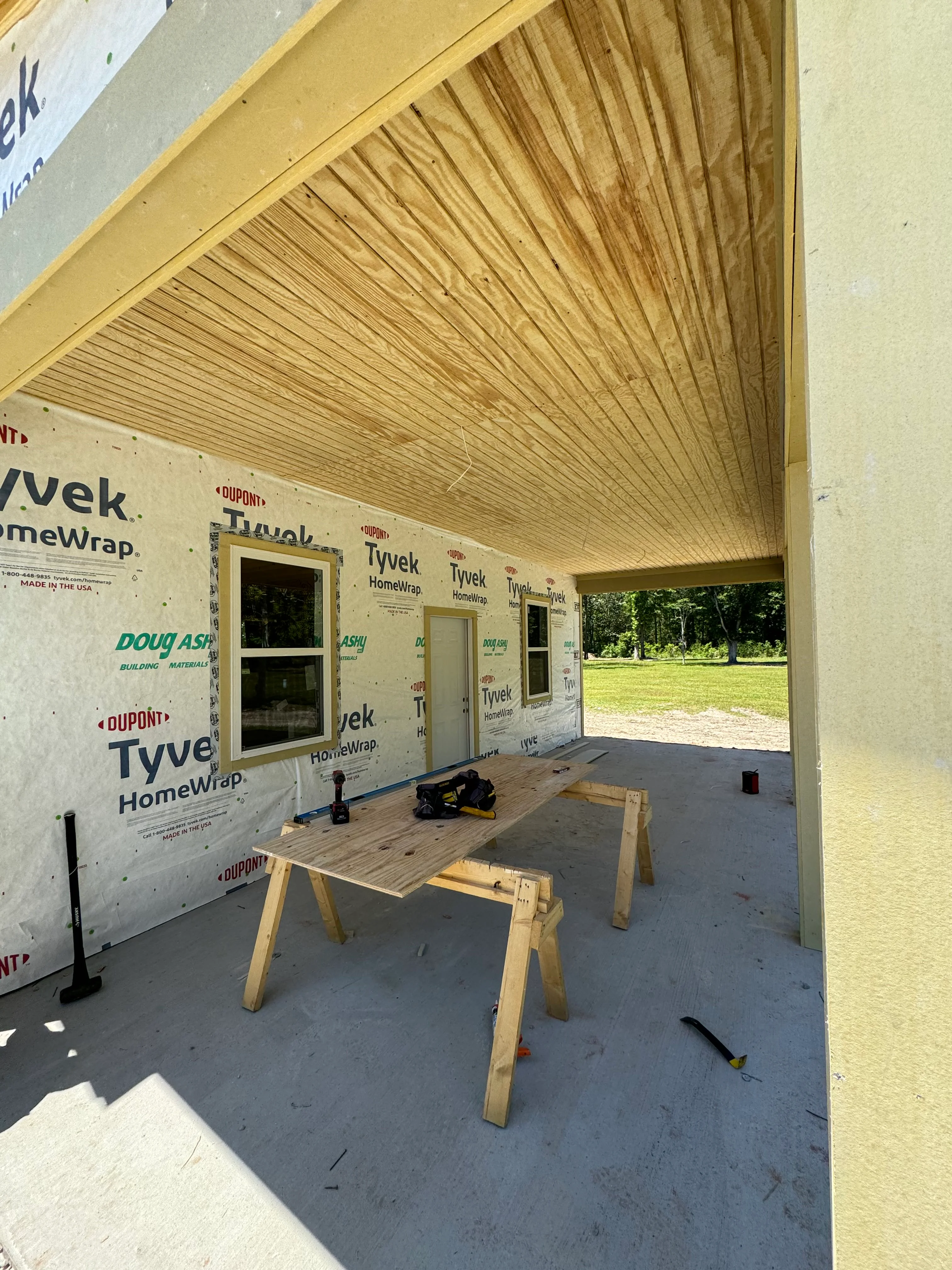 Interior view of residential addition with wood ceiling framing and Tyvek weatherproofing