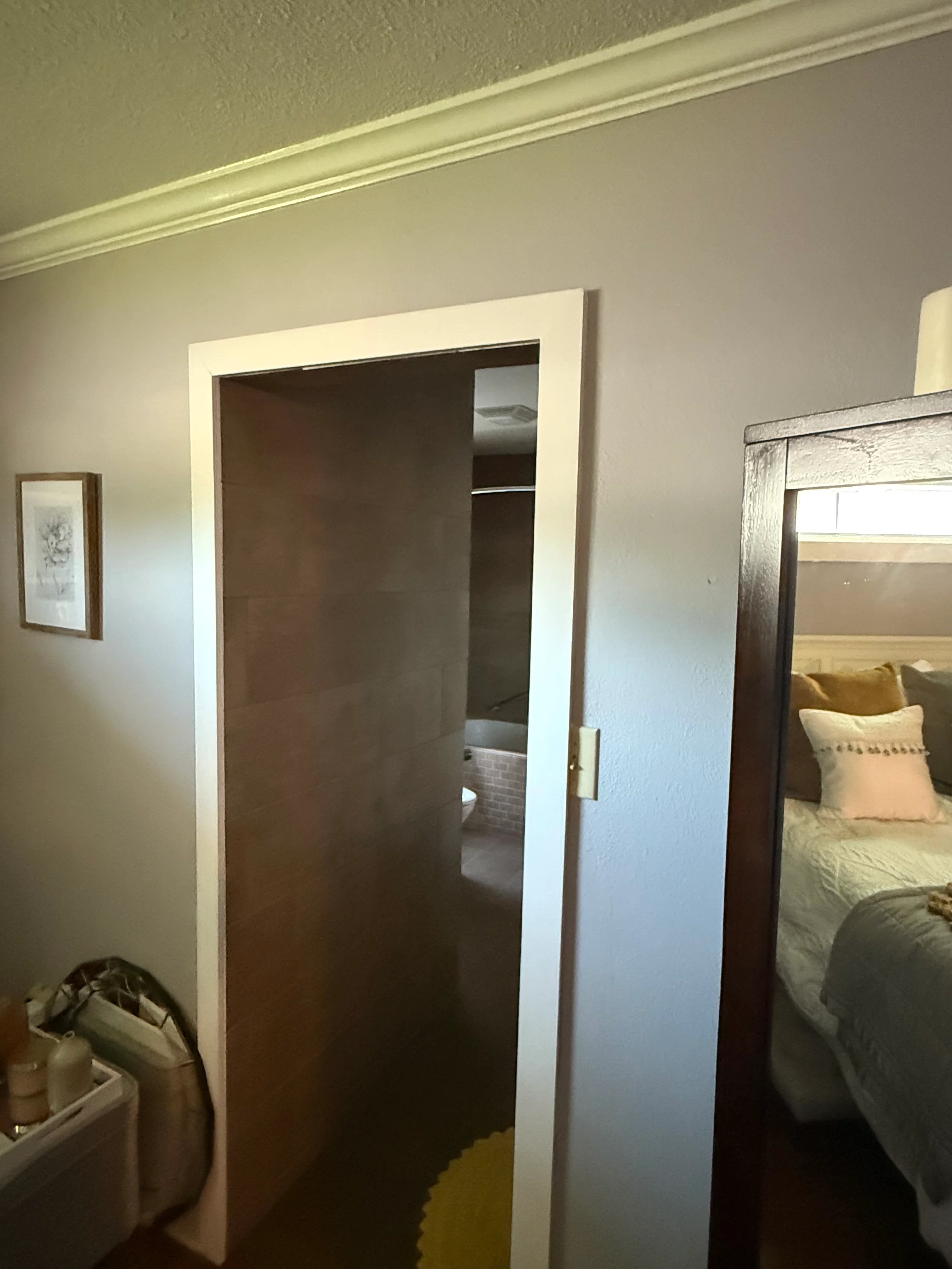 Dark wood sliding closet door with white trim frame in bedroom