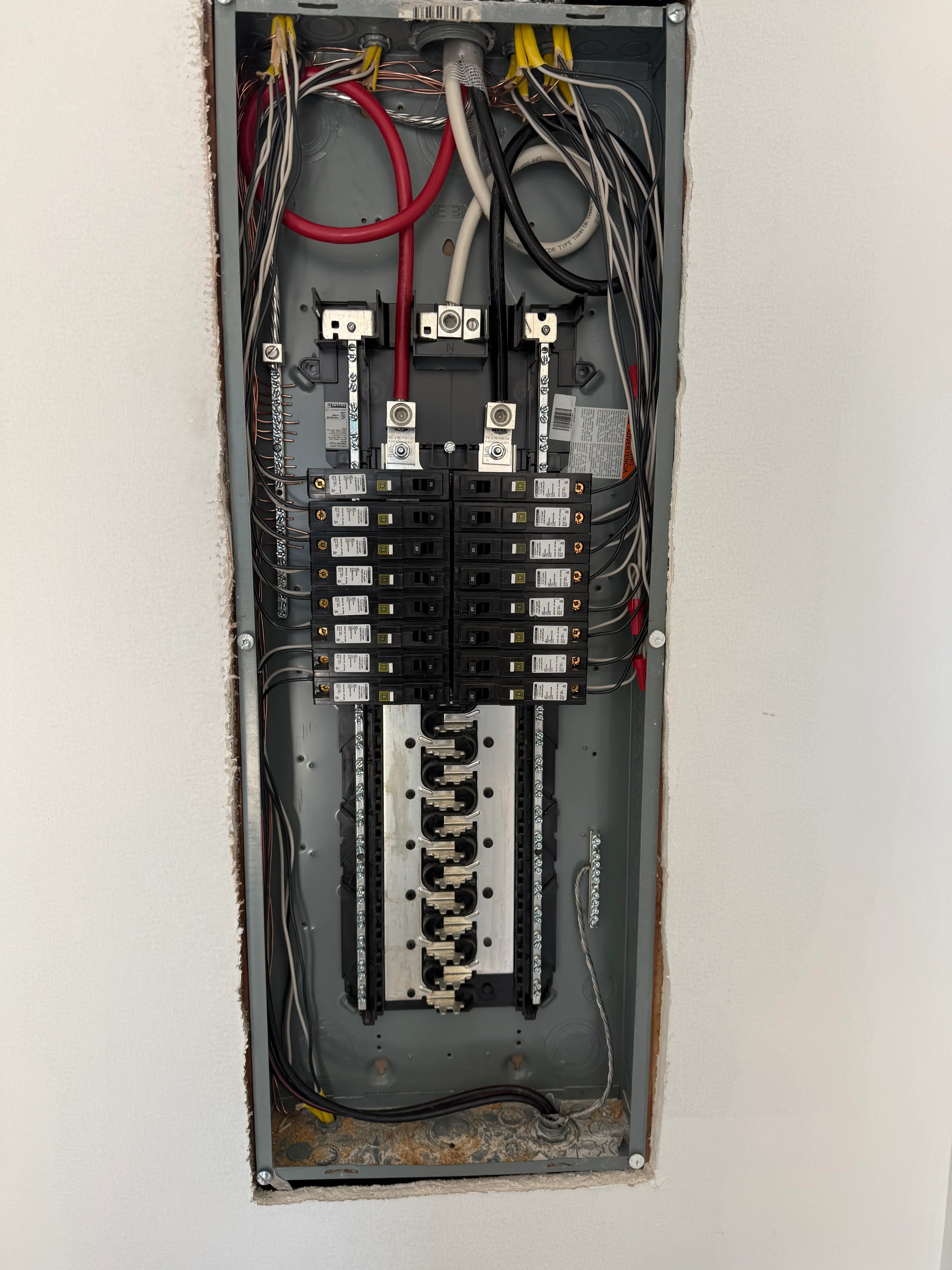 Electrical panel with breakers, organized wiring, and disconnect switches installed in wall