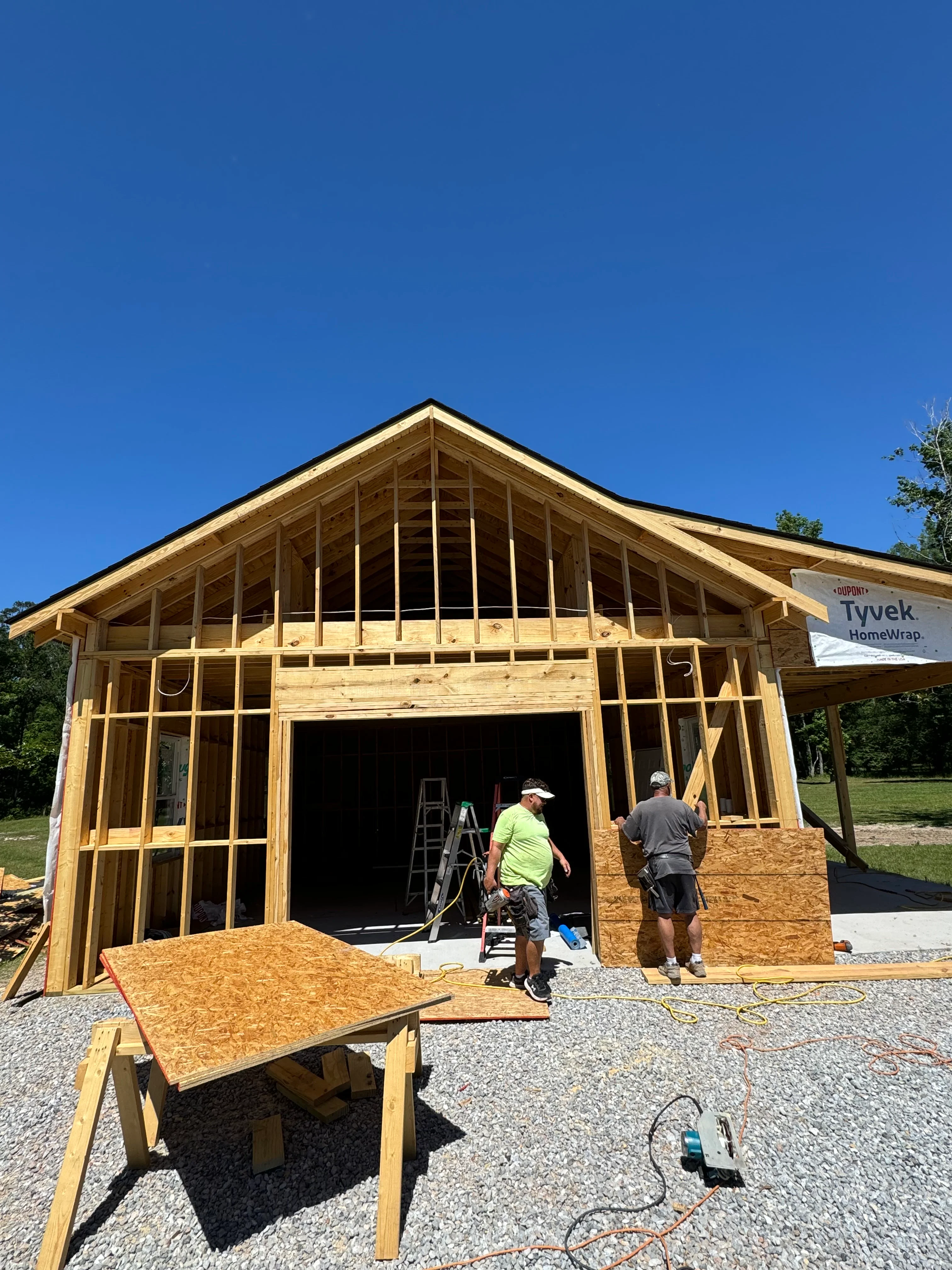New wood-framed residential house under construction with exposed beams and gable roof