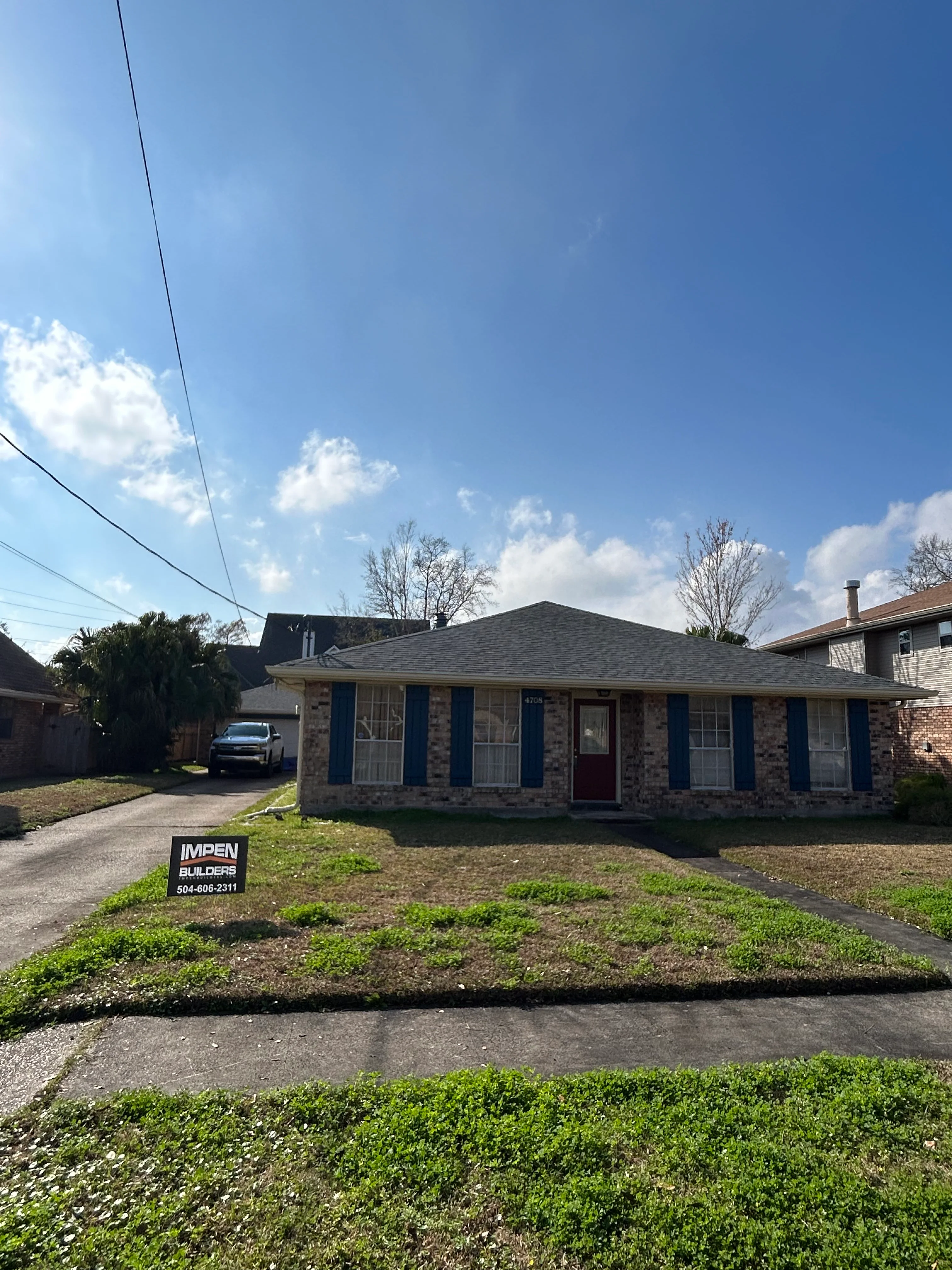 Renovated brick home with new roof, blue-trimmed windows and doors in New Orleans
