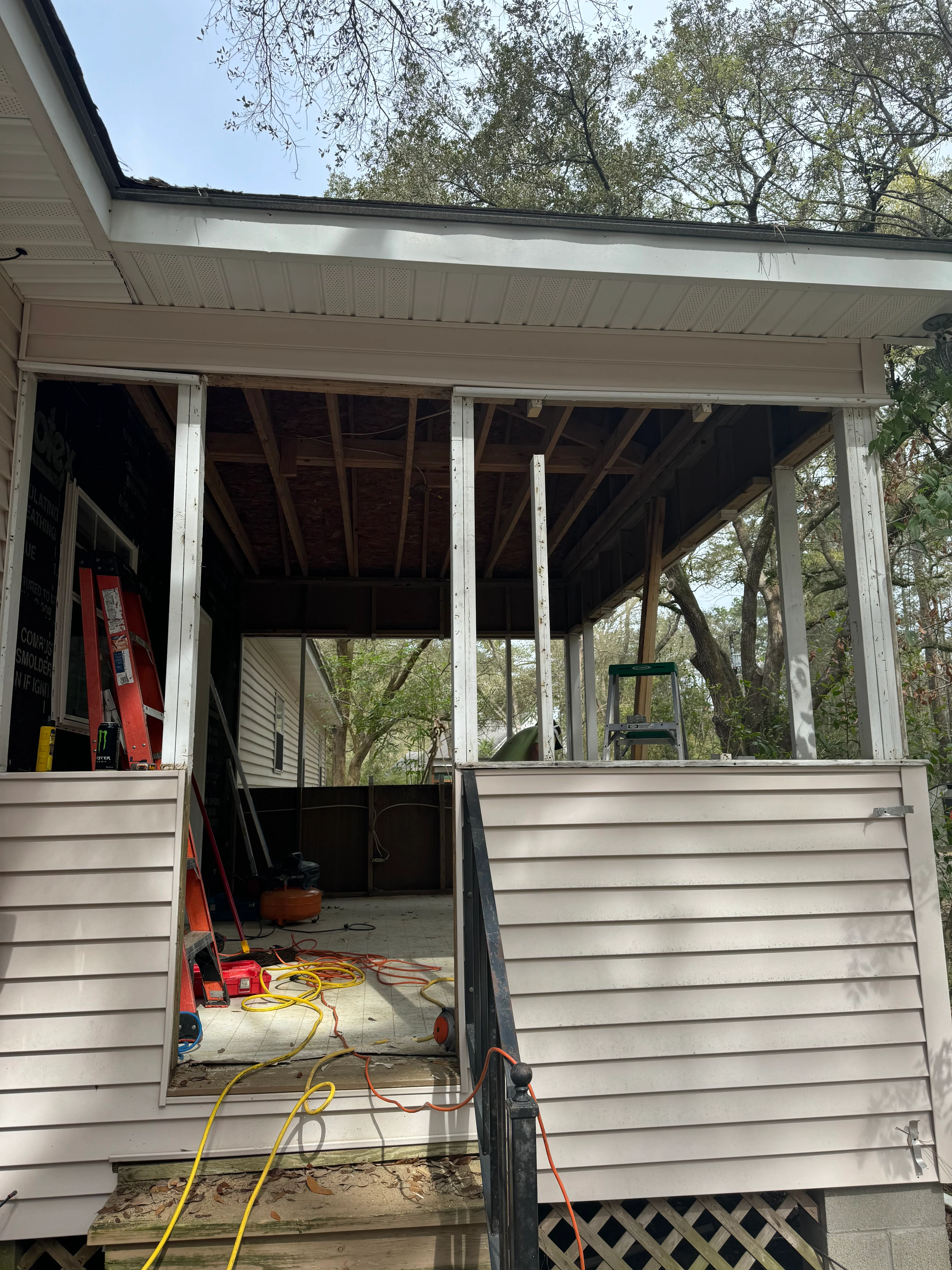 Covered porch under renovation with white metal frame and new roofing structure