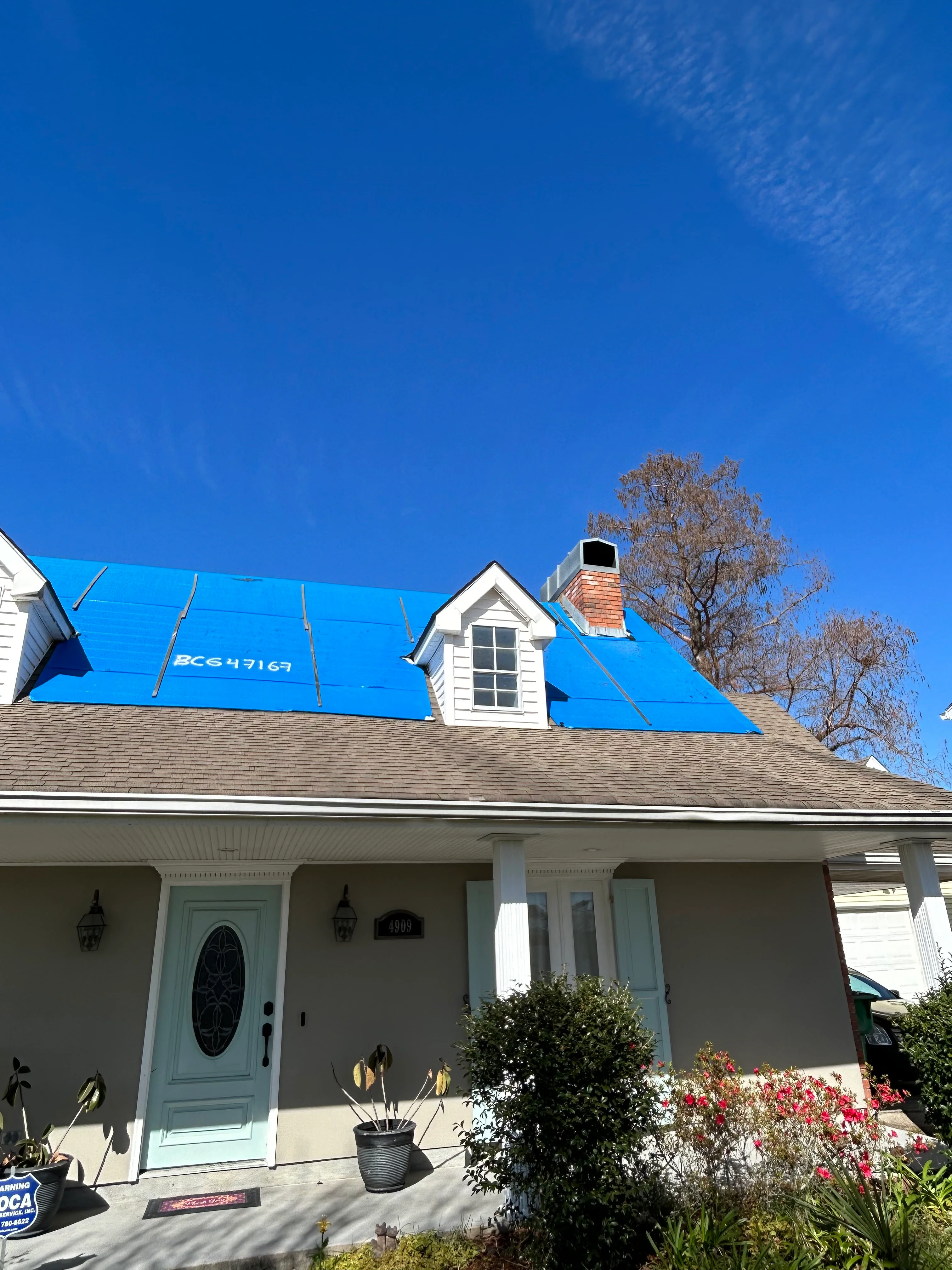 New Orleans home with fresh asphalt shingle roof installation and blue protective tarping