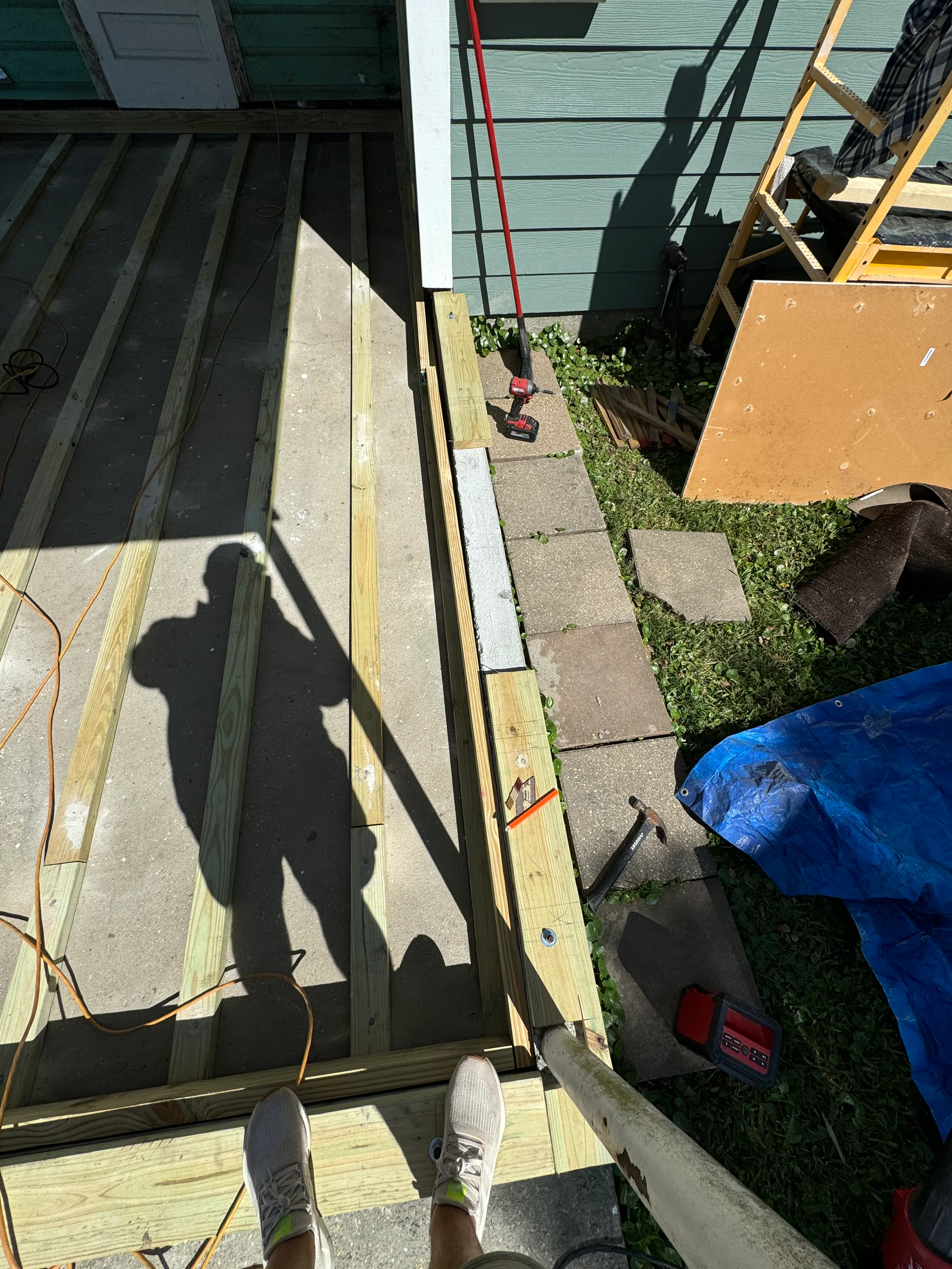 Overhead view of new wood deck framing with joists and beams under construction